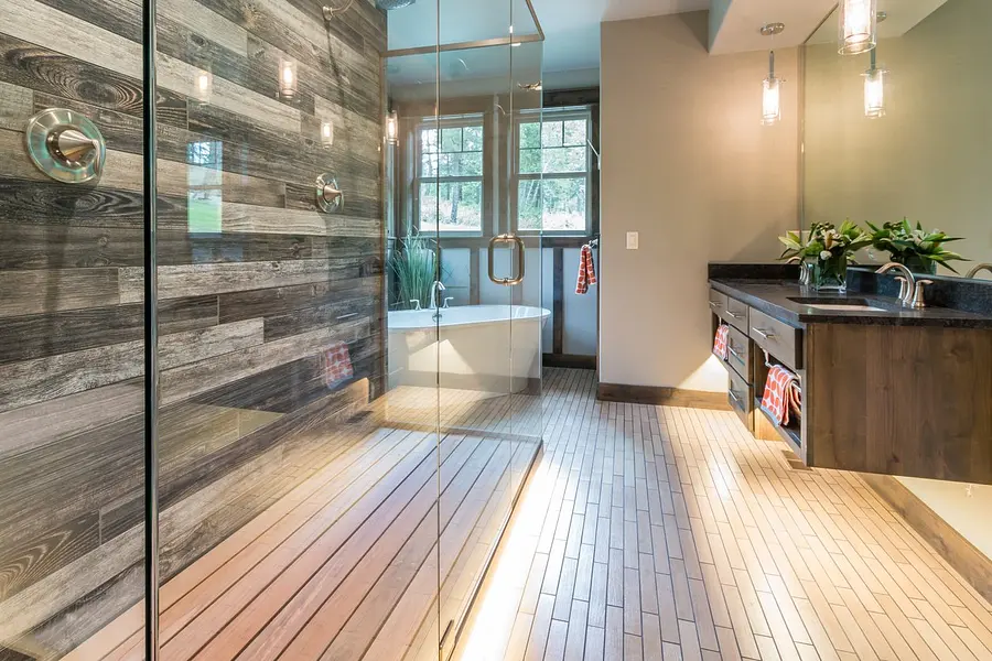 Full-height glass shower wall beside a freestanding tub in a spa-style bathroom